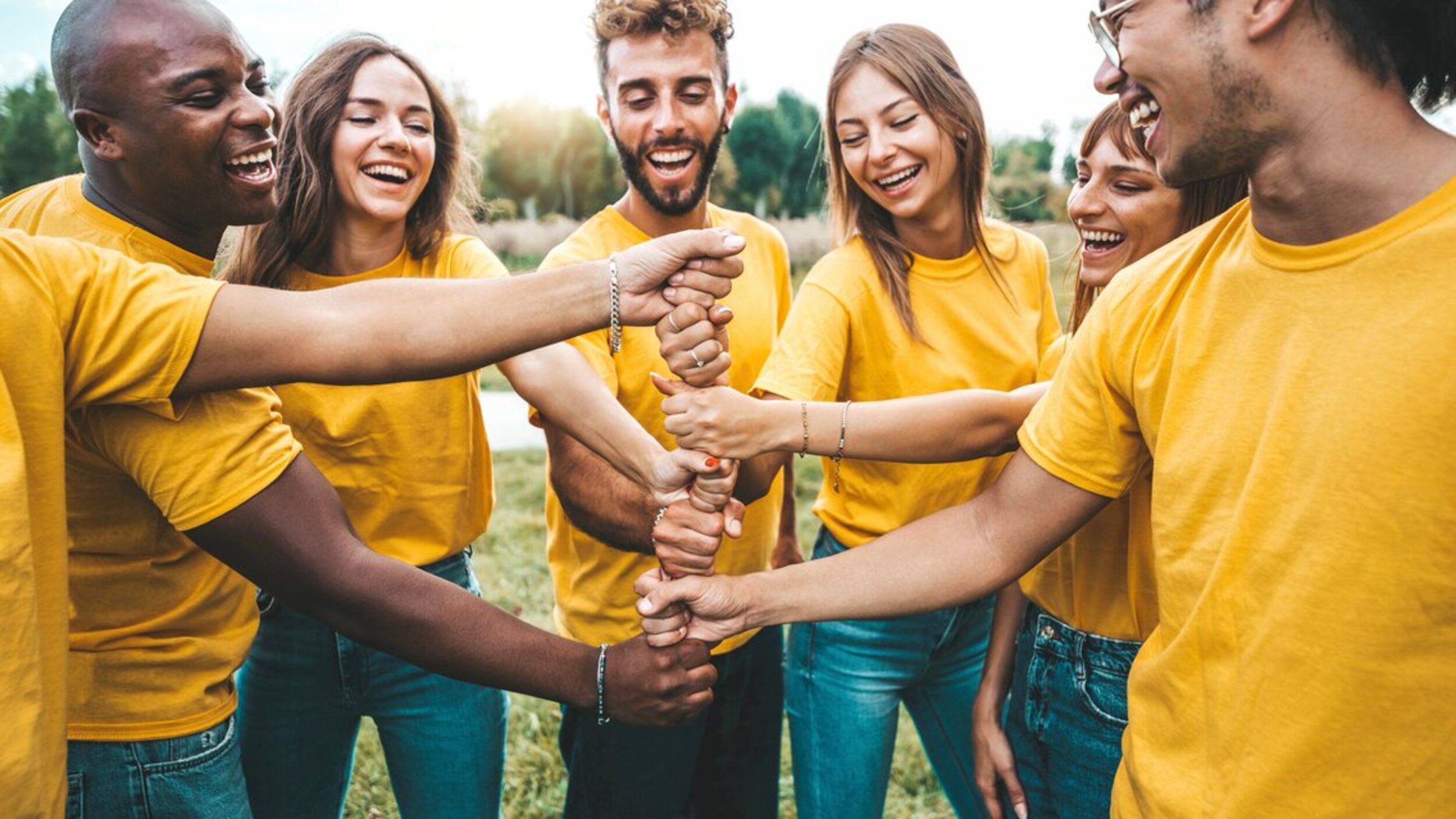 Multiracial happy young people stacking hands outside - Universi Multiracial happy young people stacking hands outside - Universi